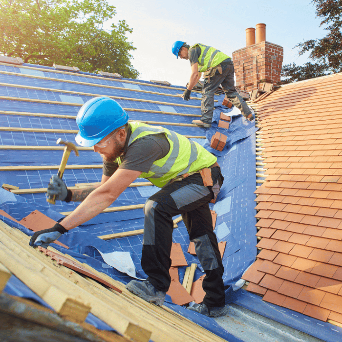 Two professional roofers installing a roof